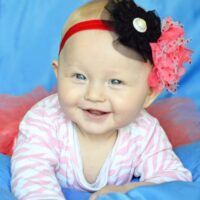 smiling baby girl with flower headband