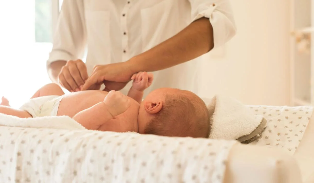 Woman changing newborn nappy