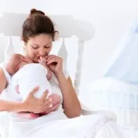 woman holding newborn in rocking chair