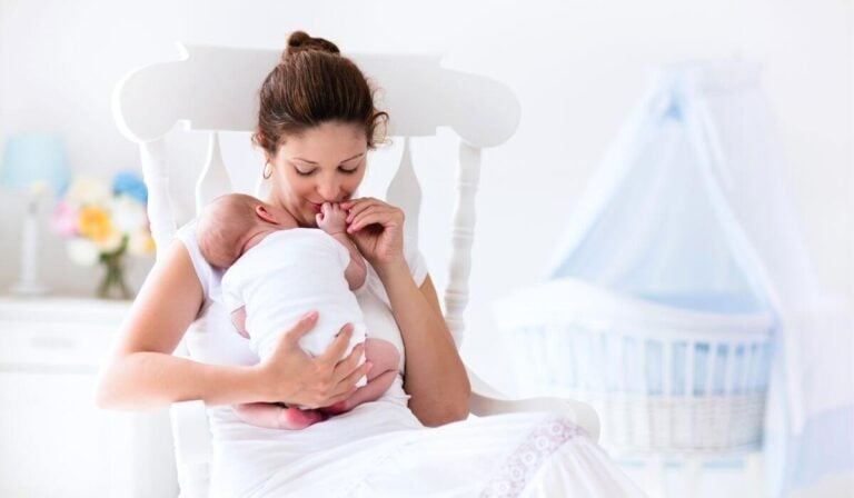 woman holding newborn in rocking chair