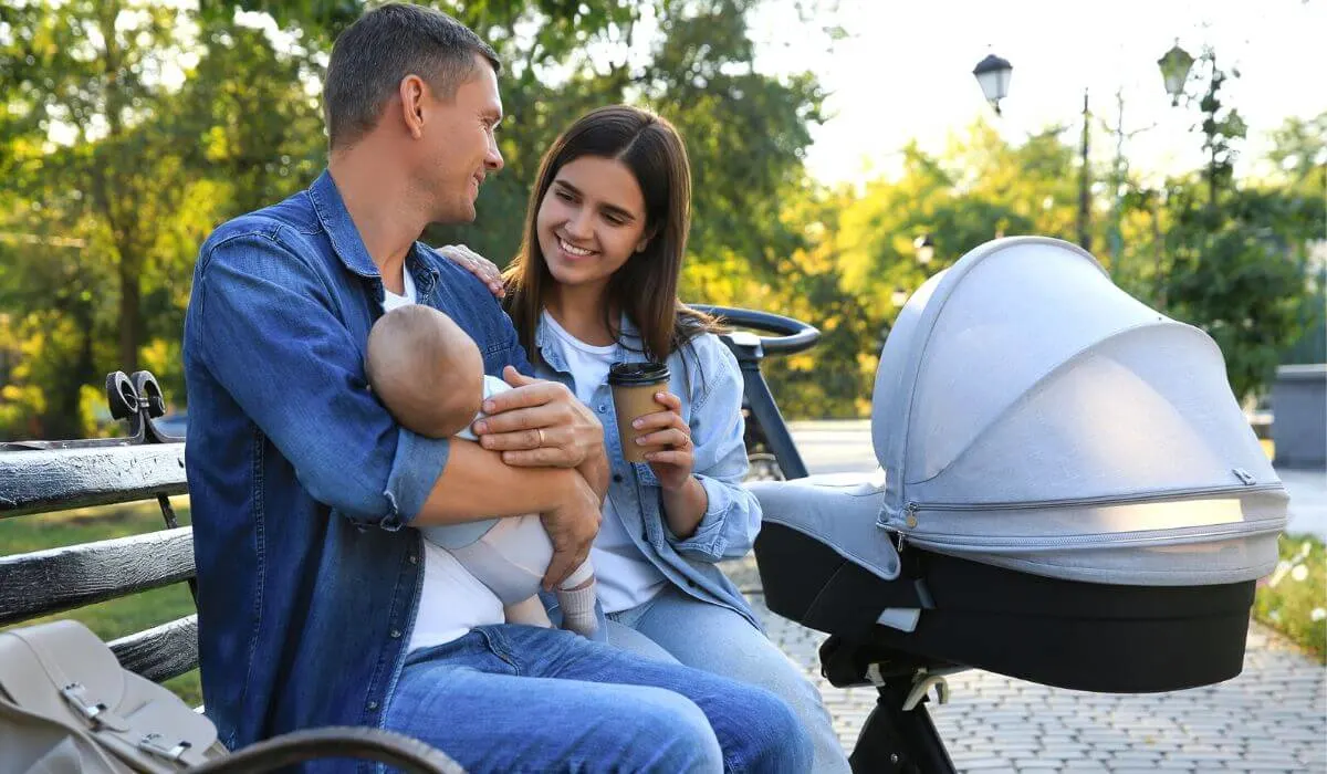 husband and wife with newborn and stroller