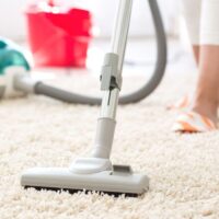 woman vacuuming plus carpet