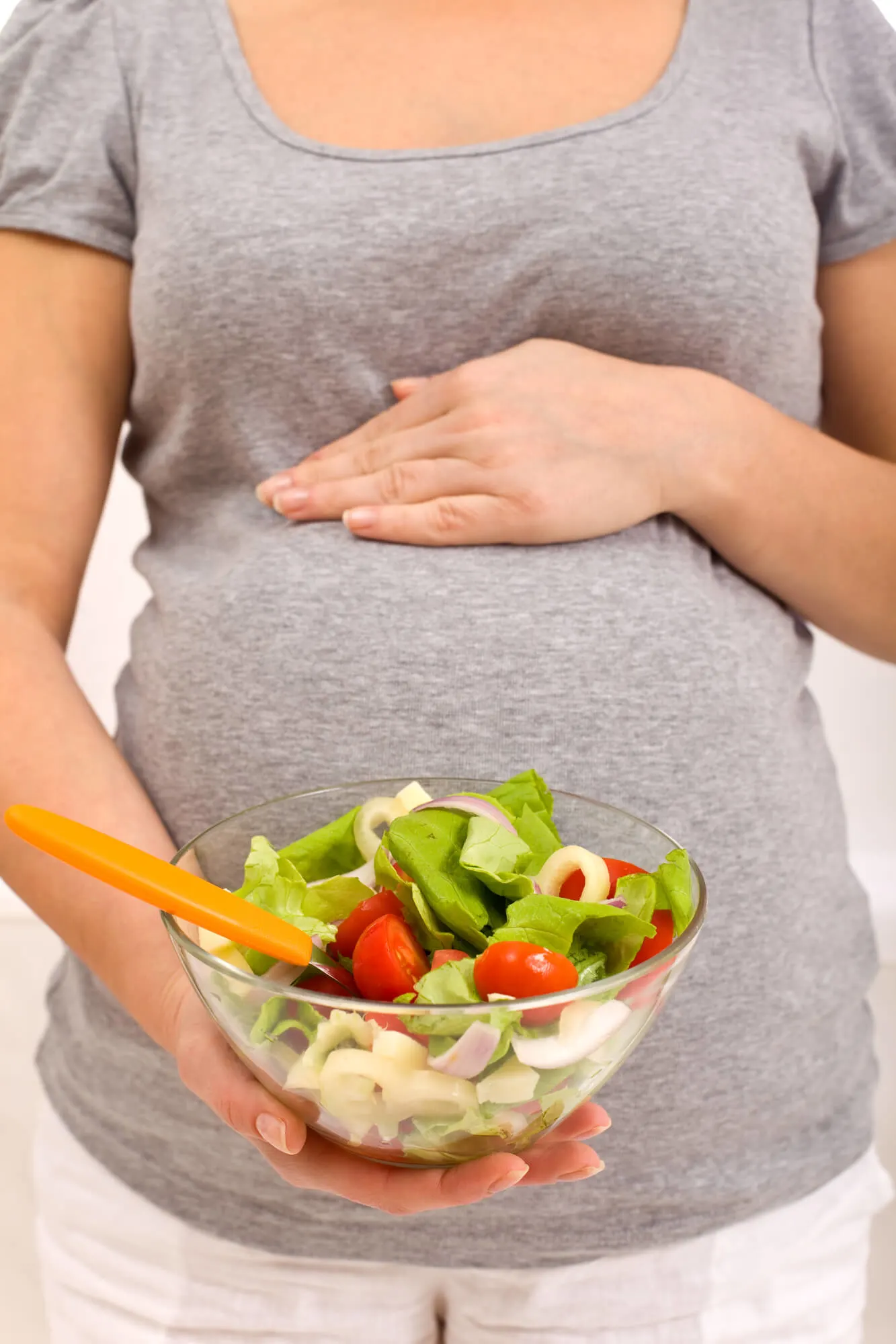 Pregnant woman with bowl of salad