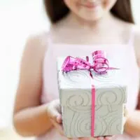 Non-toy gift ideas for kids girl holding gift box