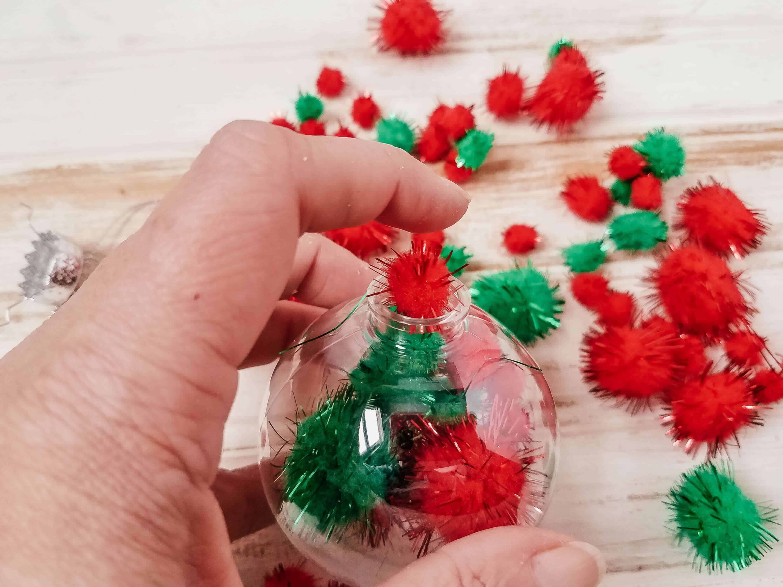 DIY Pom Pom Christmas Decorations Kids Can Make In 2 Minutes 4 Add pom poms to bauble
