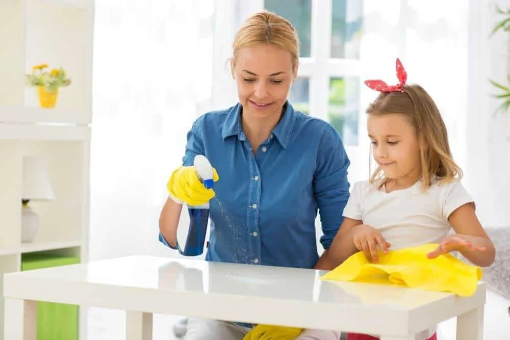 Mother teaching child how to clean bench