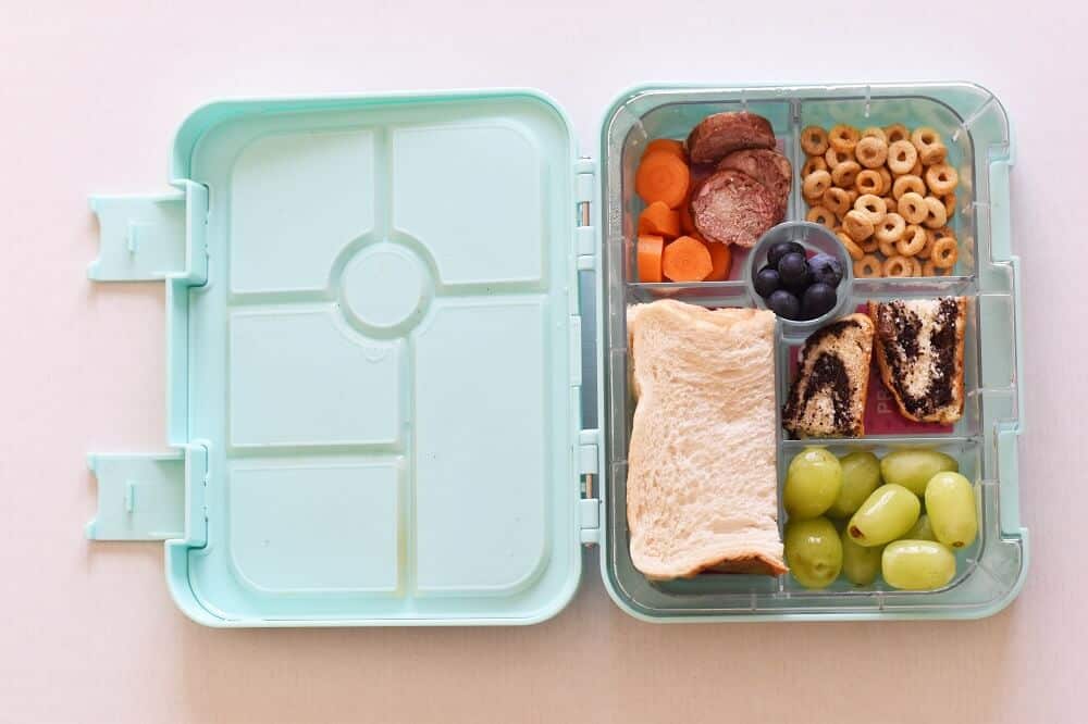 Bento box open with sandwich and snacks