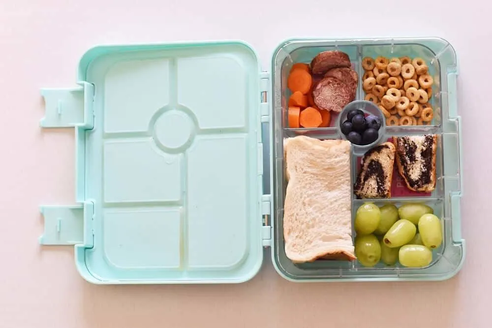 Bento box open with sandwich and snacks