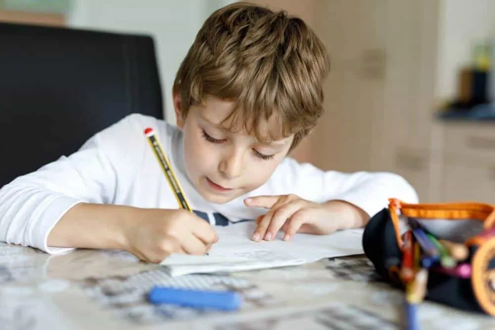 Young boy working on school work at home