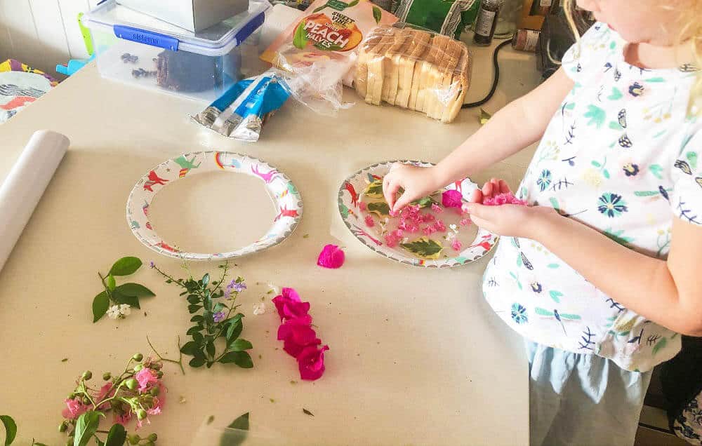 Child placing flowers on paper plate