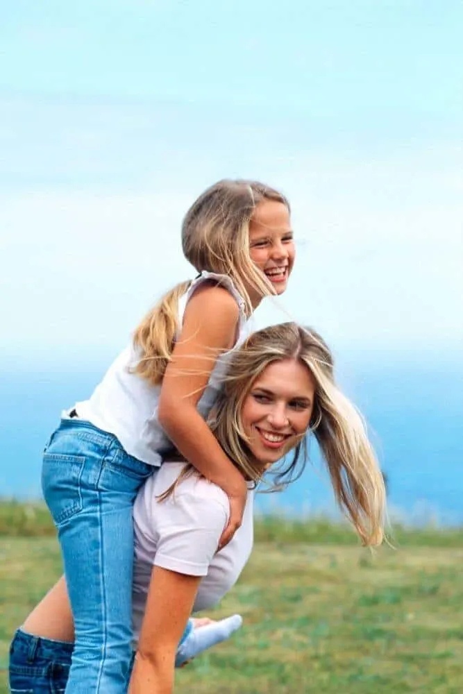 Mother giving daughter piggy back