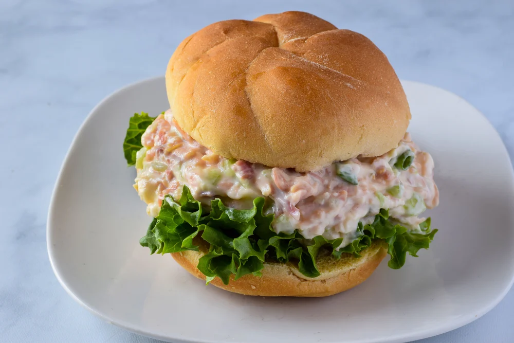 turkey salad on a bread roll with lettuce.
