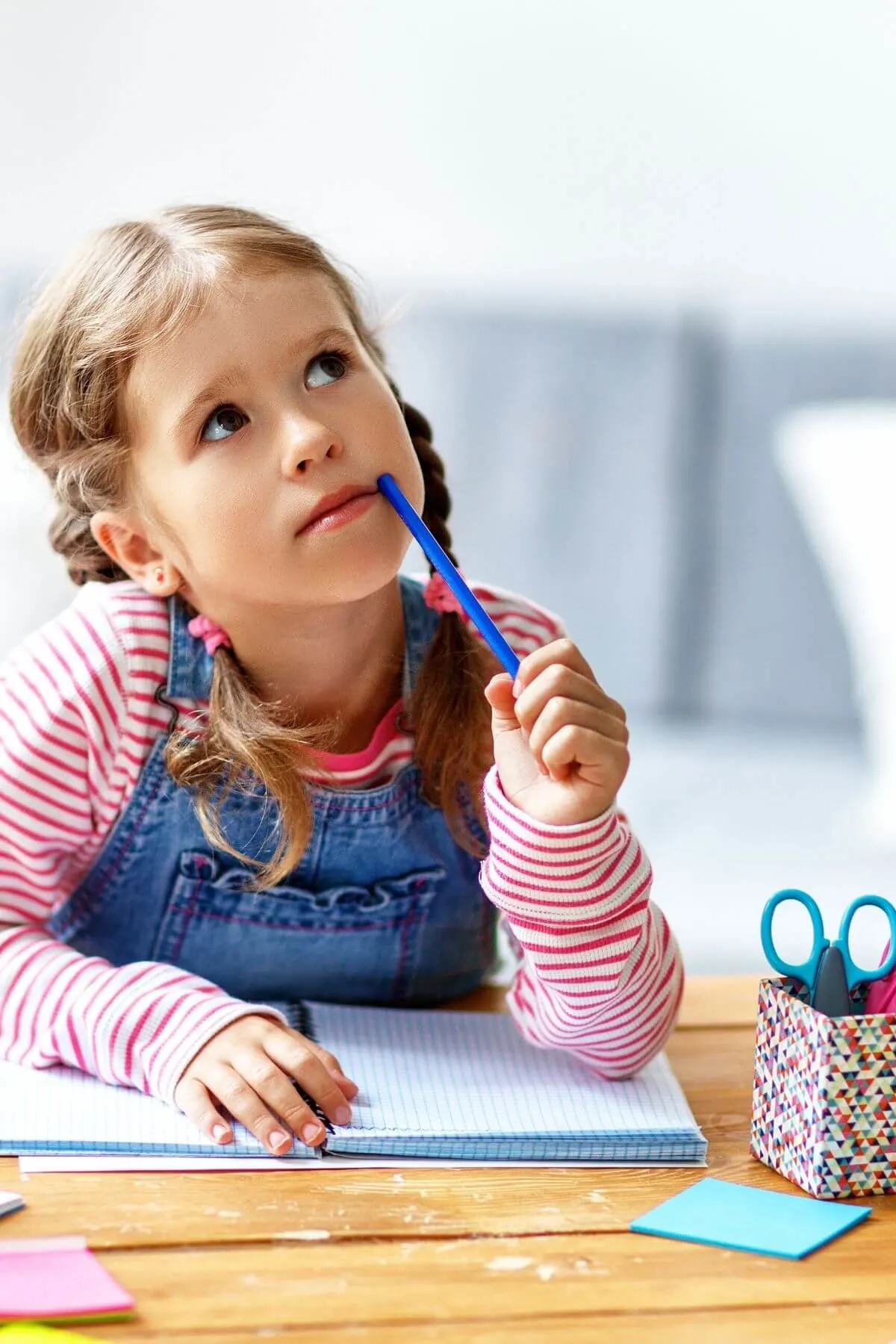 Young girl thinking what to write in notepad