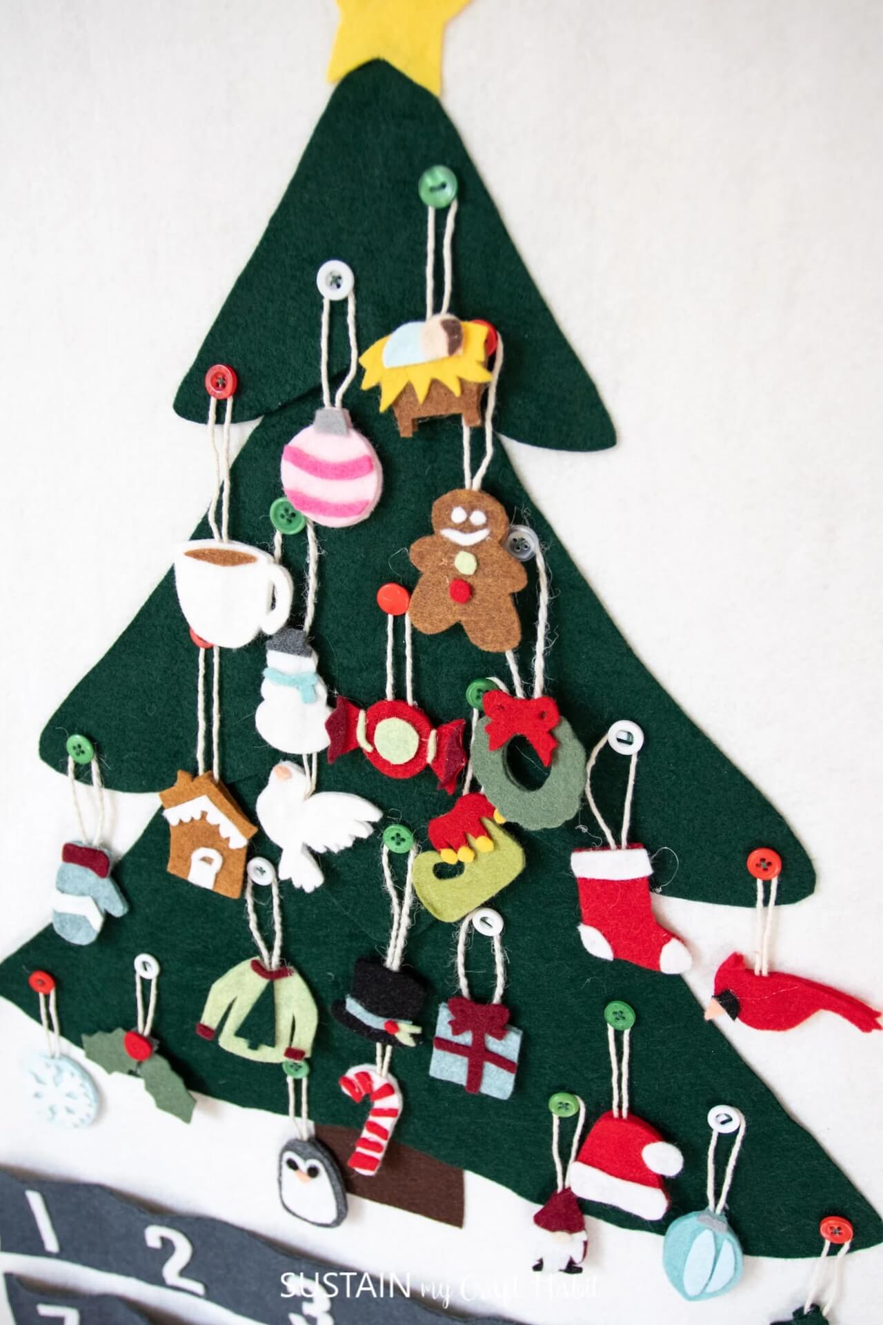 Diy felt advent calendar shaped like a christmas tree with decorations.