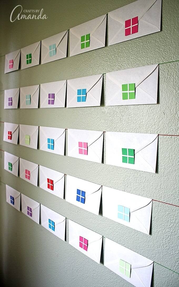Envelope advent calendar hanging on a wall.