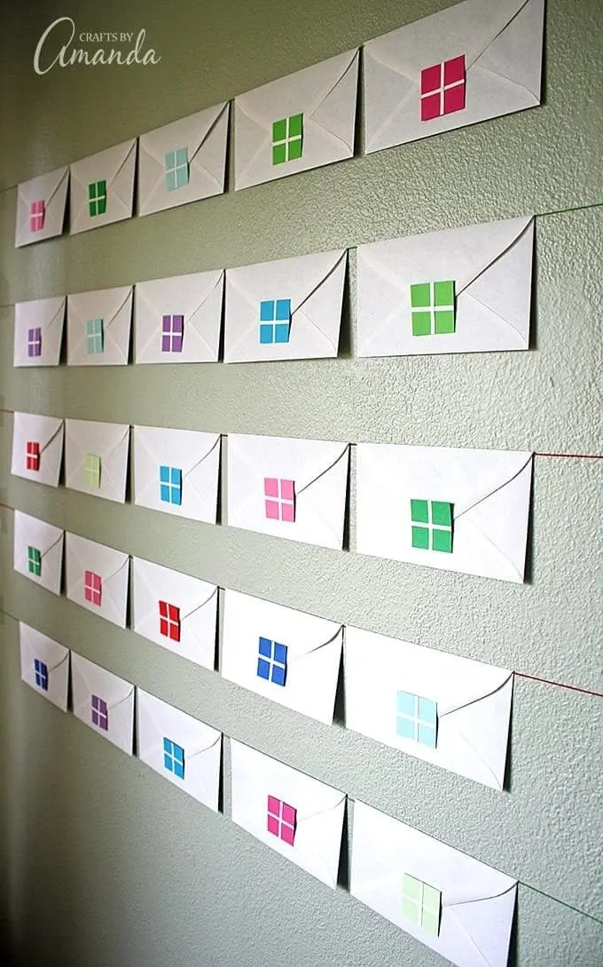 Envelope advent calendar hanging on a wall.