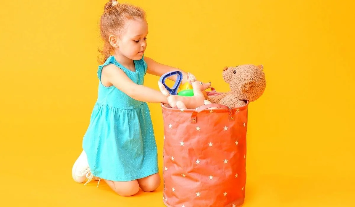 Little girl putting toys in bag