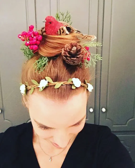 Birdsnest hairstyle with pinecone, bird, berries and foliage on a woman.