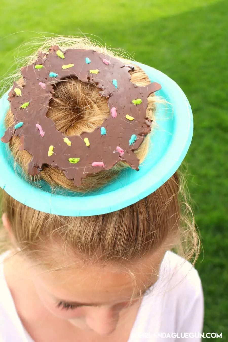 Donut hairstyle on a paper plate with chocolate icing.