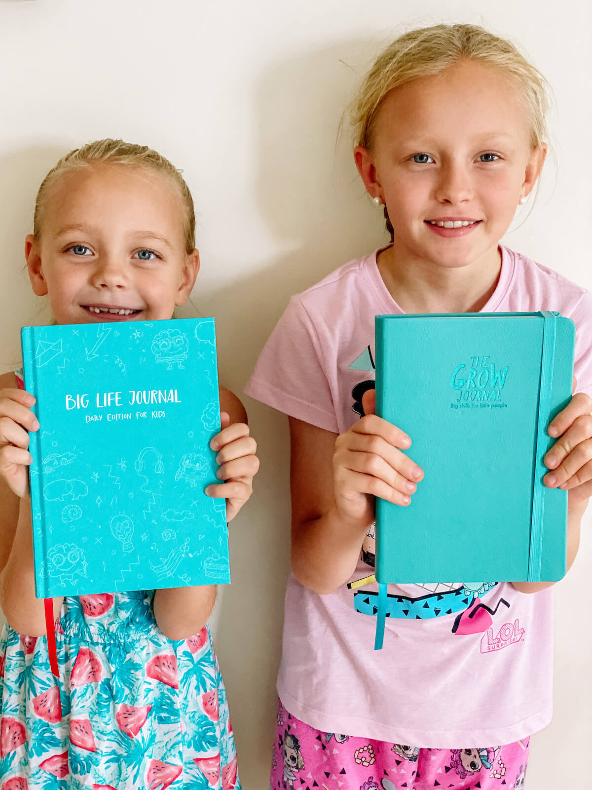 kids holding their gratitude journals up with big life journal daily and the grow journal