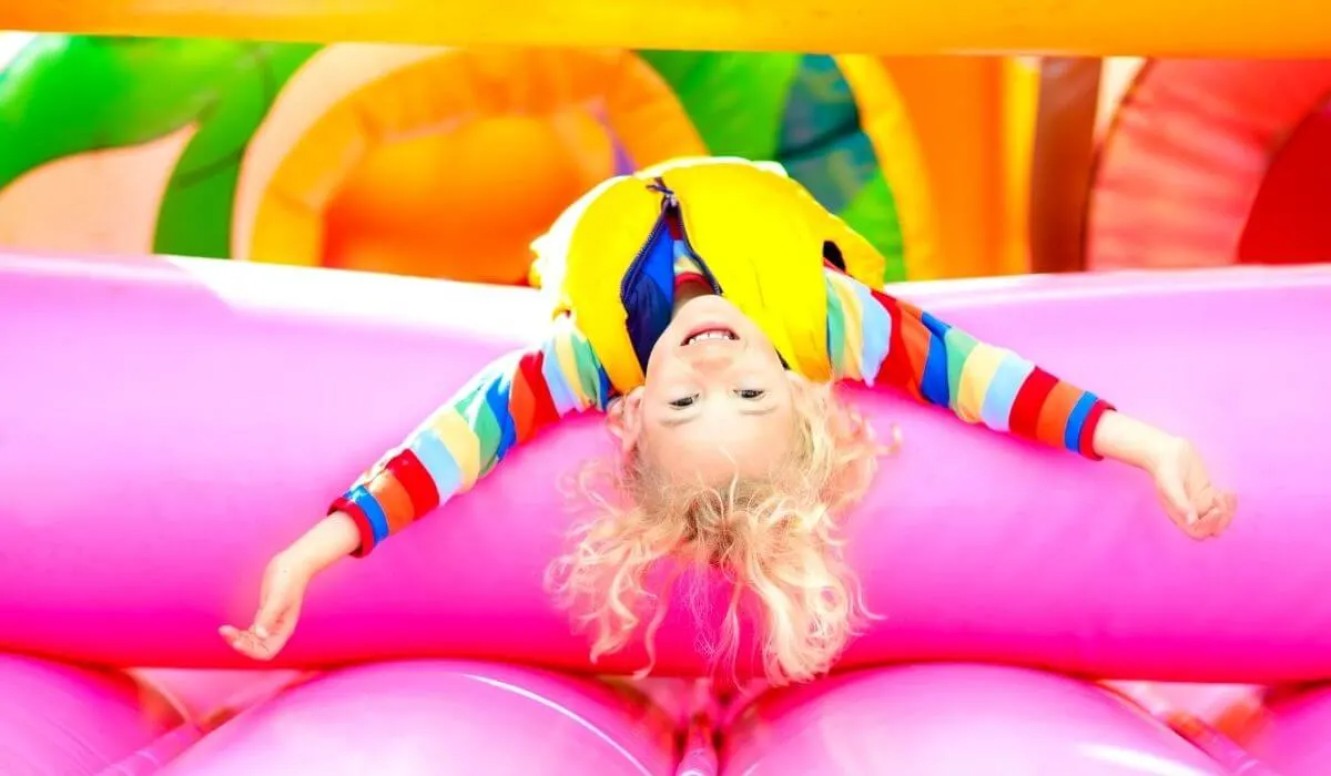 child upsidedown on jumping castle