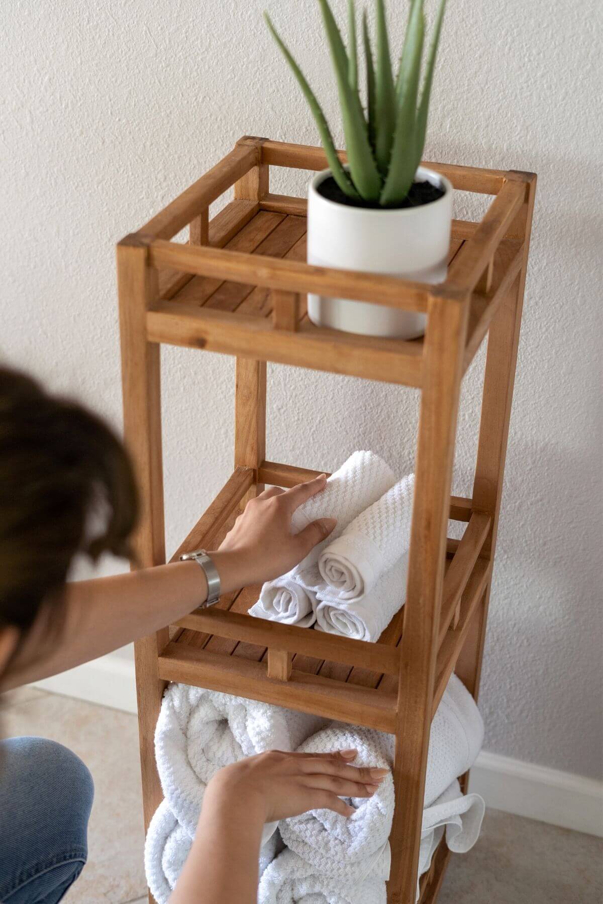 woman folding towels on a shelf