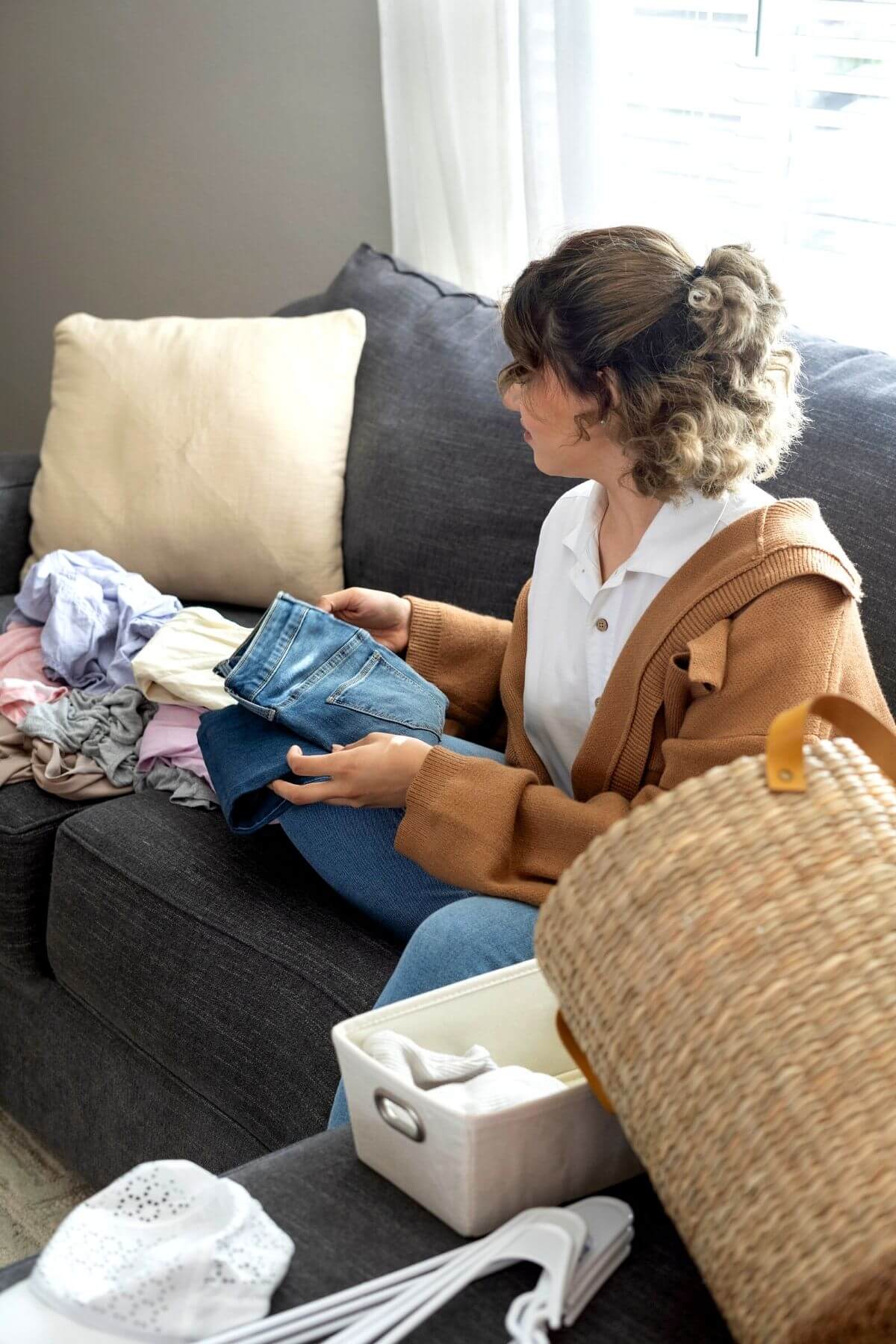 Woman sorting through clothing to declutter