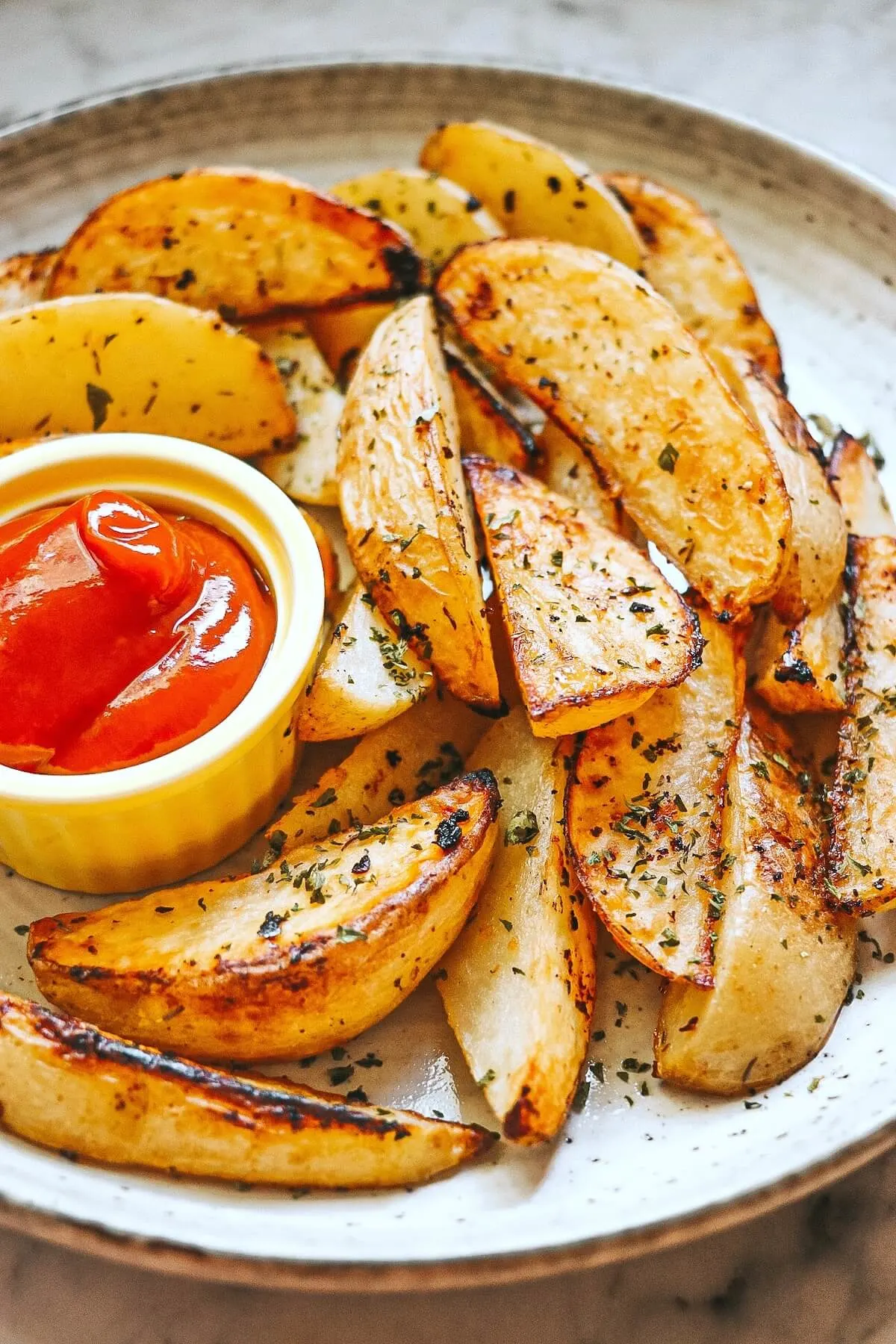 Potato wedges on a plate with tomato sauce