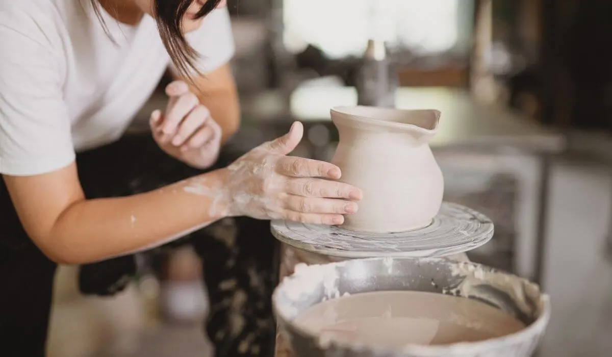 mujer en taller de cerámica haciendo una jarra