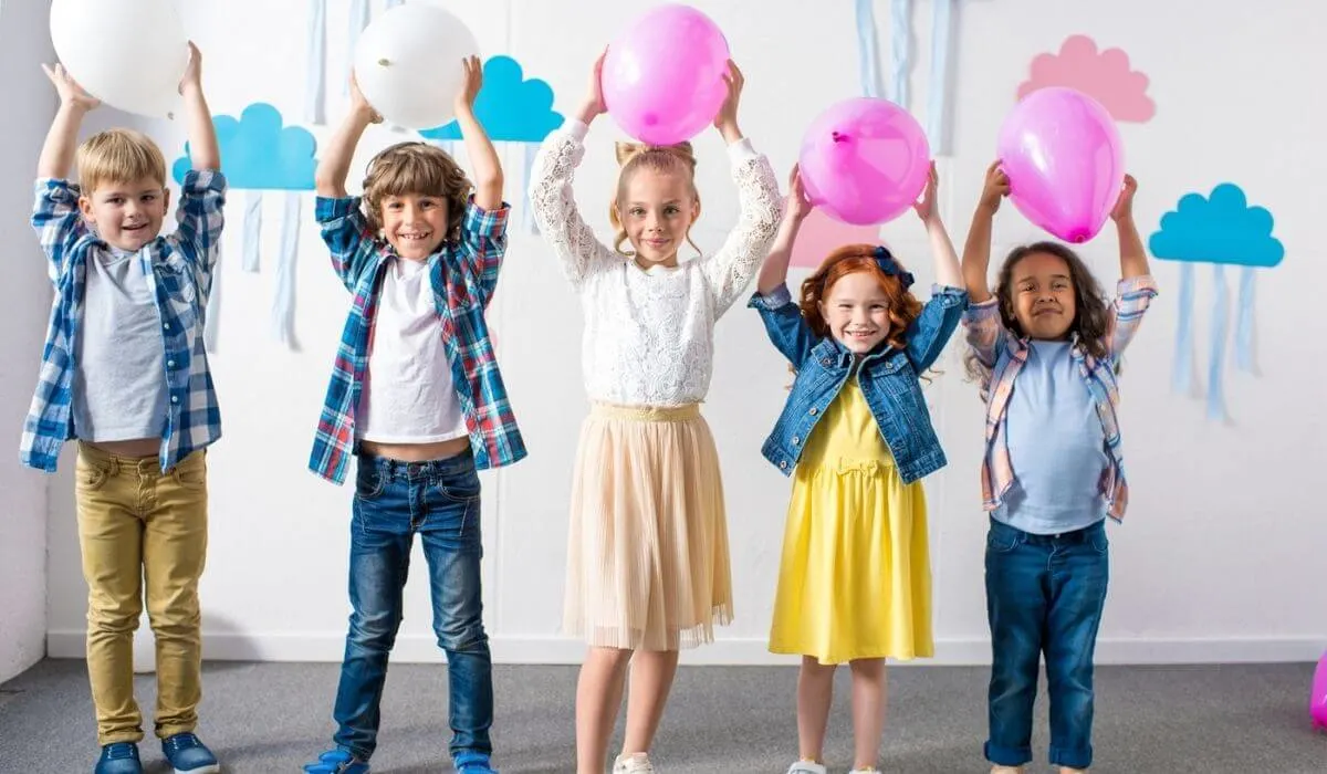 niños en la fiesta de cumpleaños con globos sobre sus cabezas