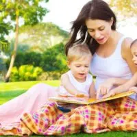 mother reading a picture book with her 2 kids