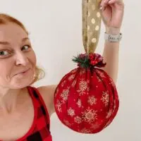 woman holding giant christmas ornament