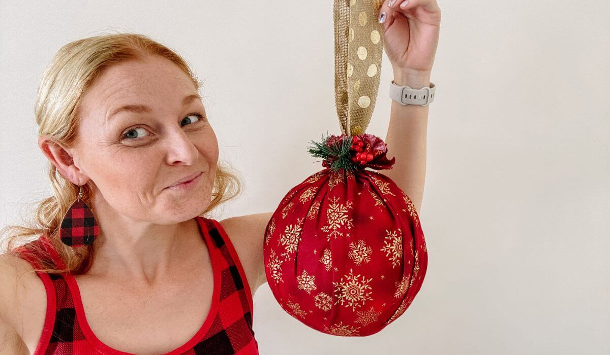 Woman holding giant christmas ornament