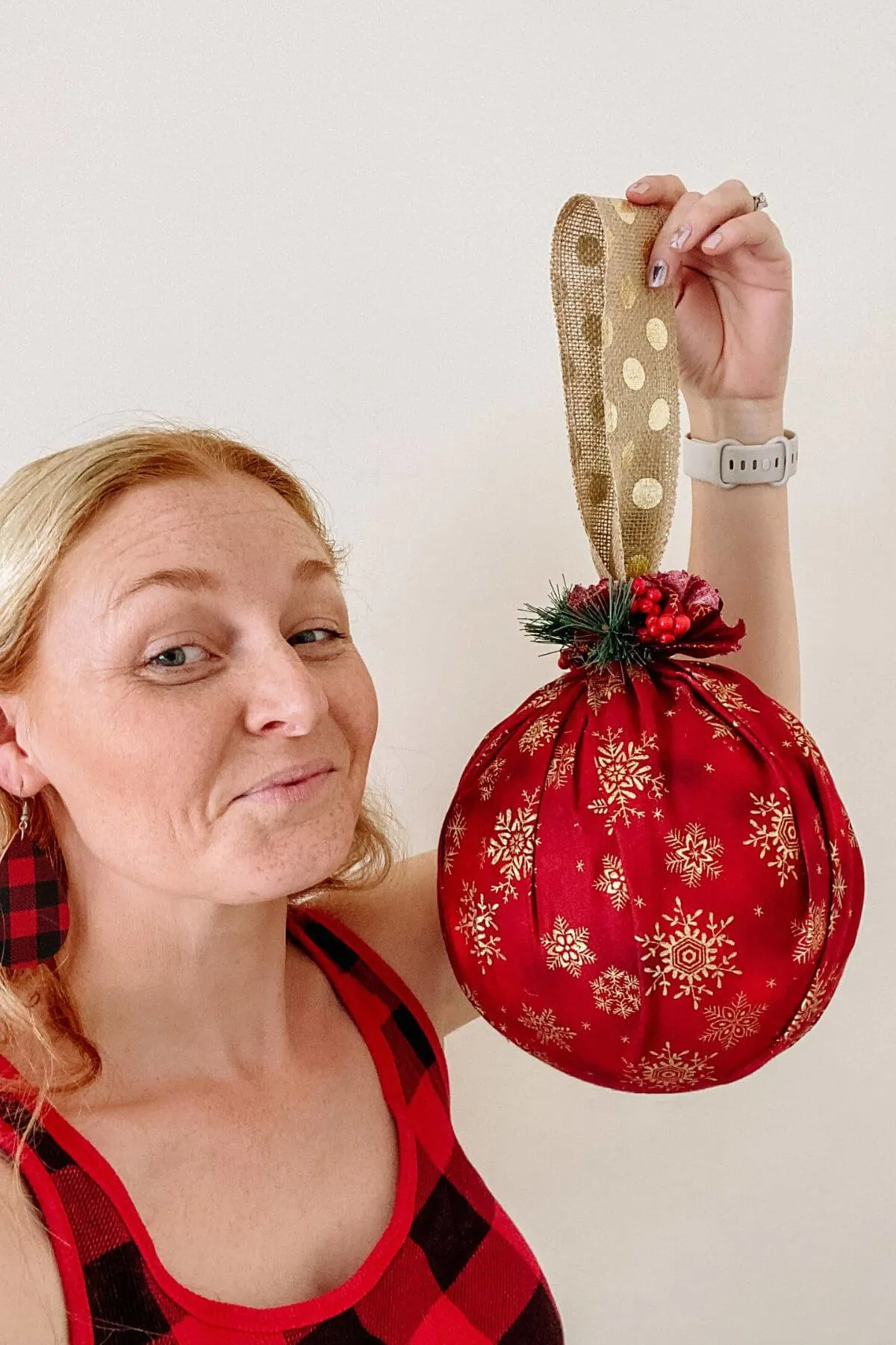 Woman holding oversized christmas ornament