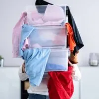 woman with tubs full of clothes during a declutter