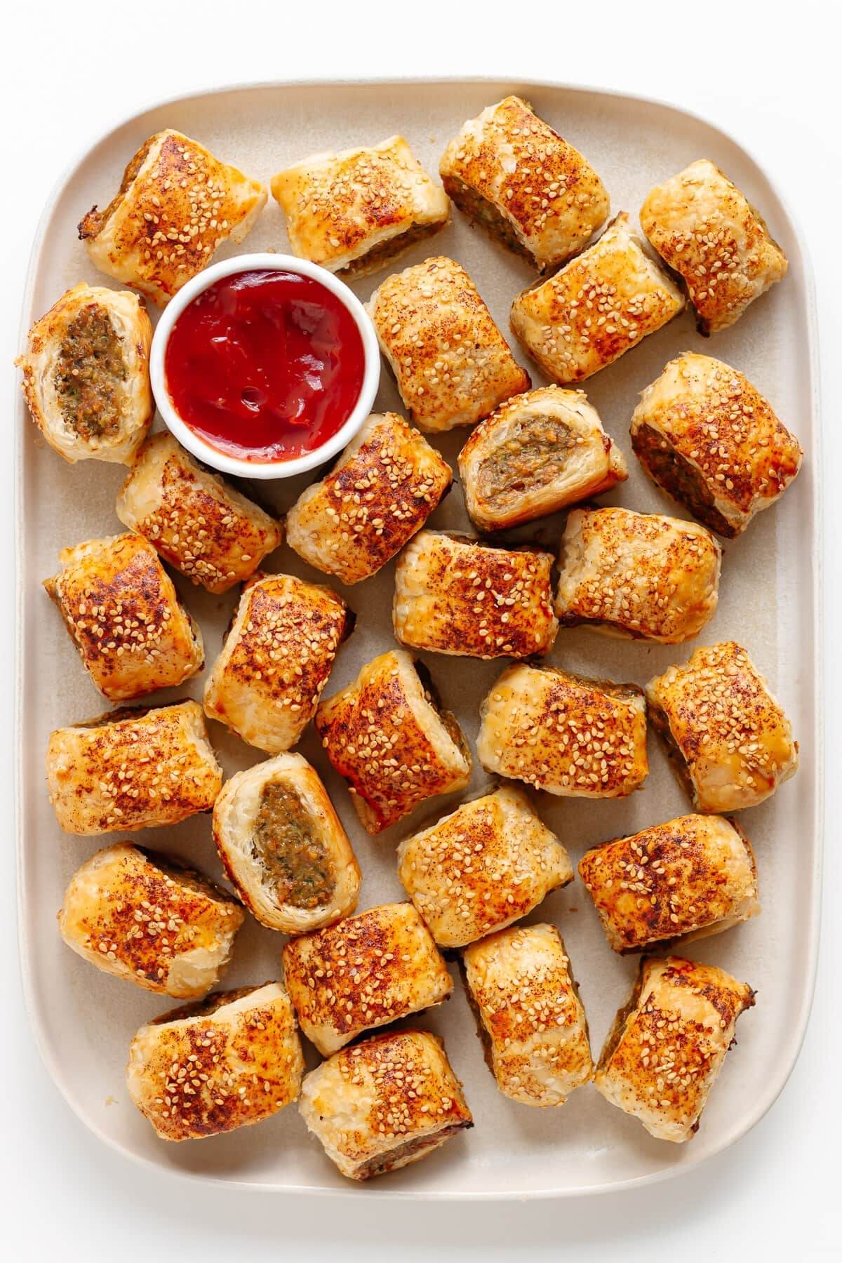 White tray with chicken sausage rolls and sauce