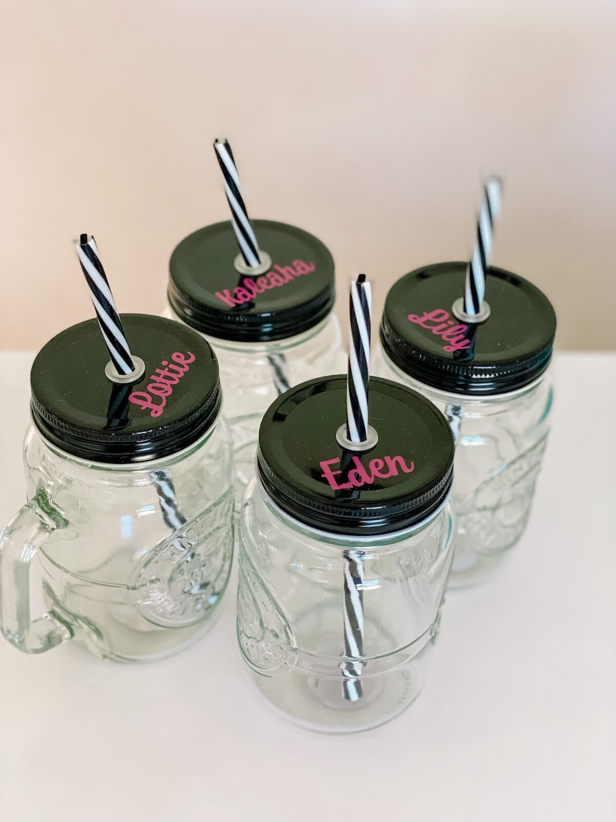 Glass jar mugs with straws with names on them in pink vinyl