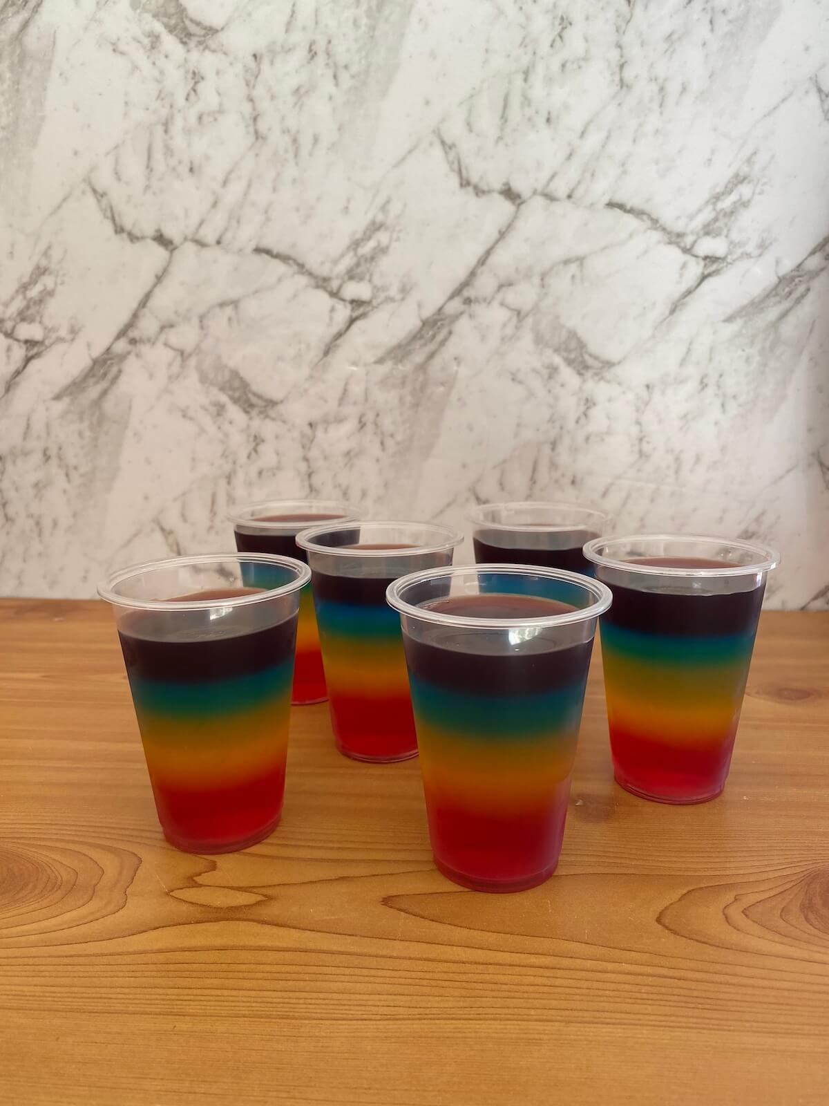 Cups of rainbow jelly on a table