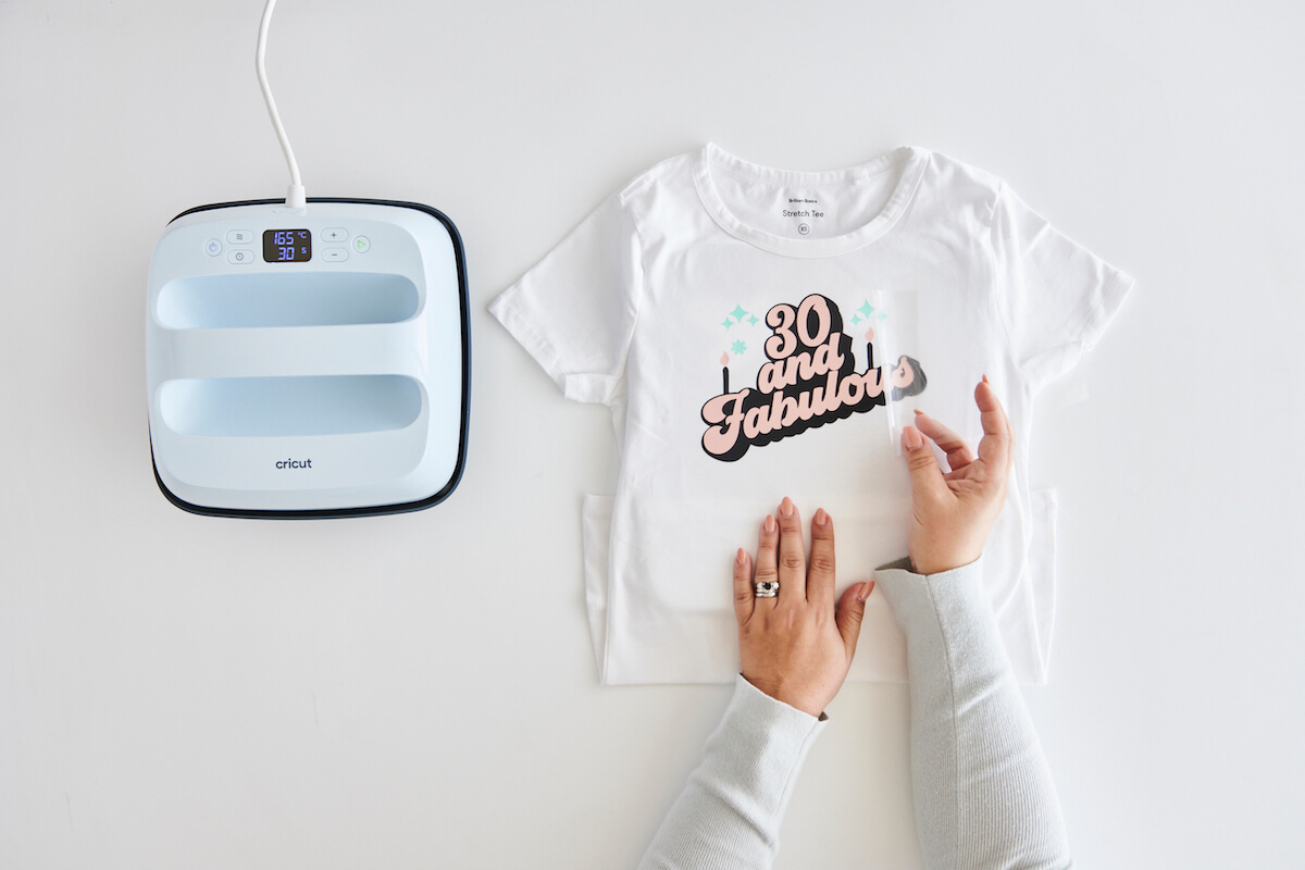 Woman finishing a cricut vinyl tshirt project with an easypress