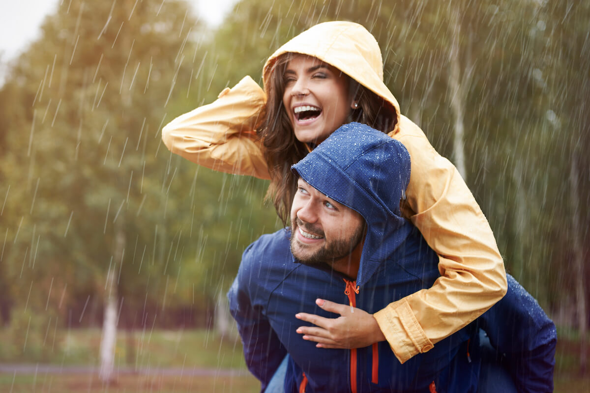 Man giving woman piggyback in the rain