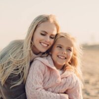 mother and daughter hugging at the beach