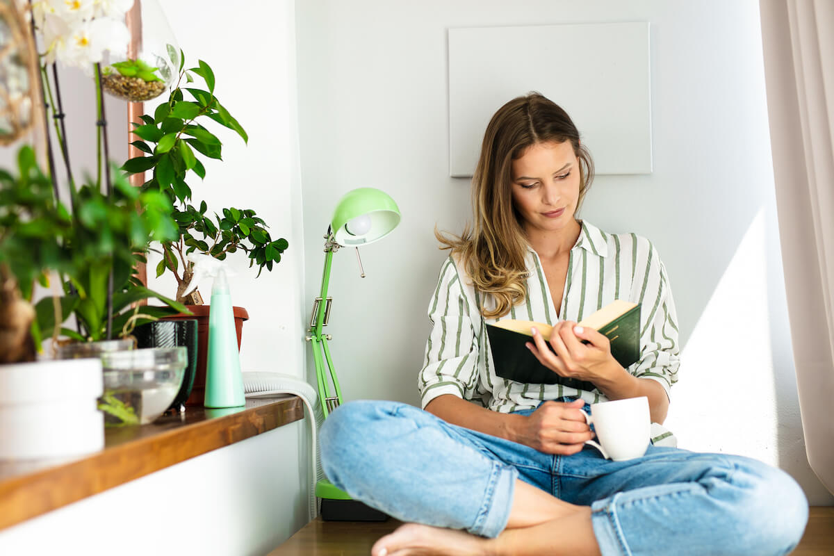 Woman reading a book with a cup of coffee in hand