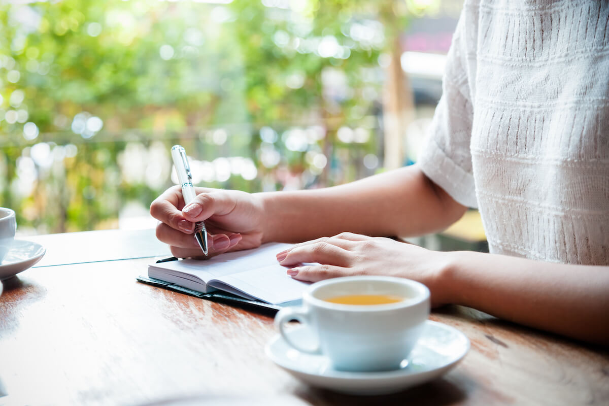 Woman in cafe writing in journal