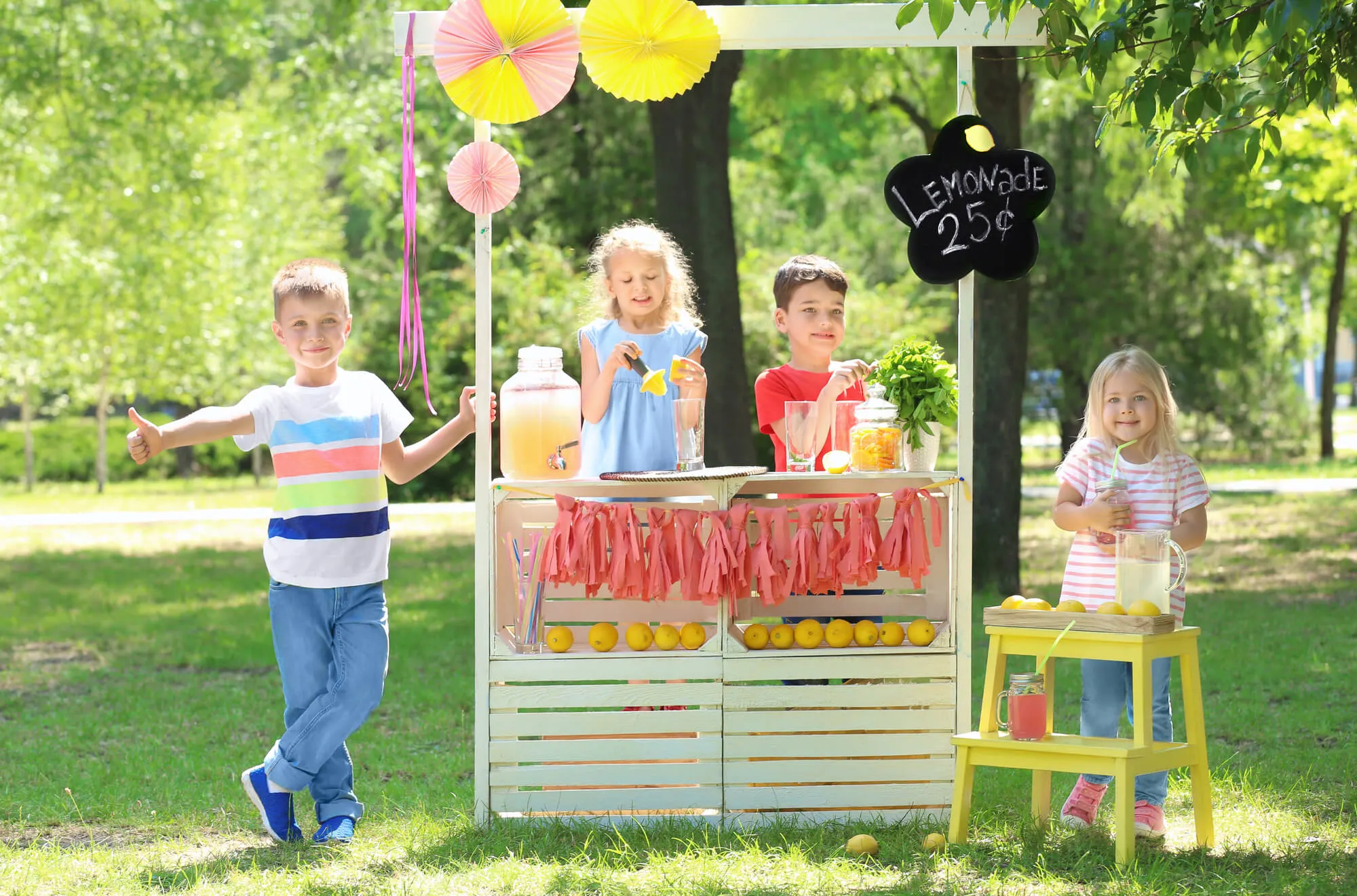 4 kids with a lemonade stand outdoors selling for 25 cents