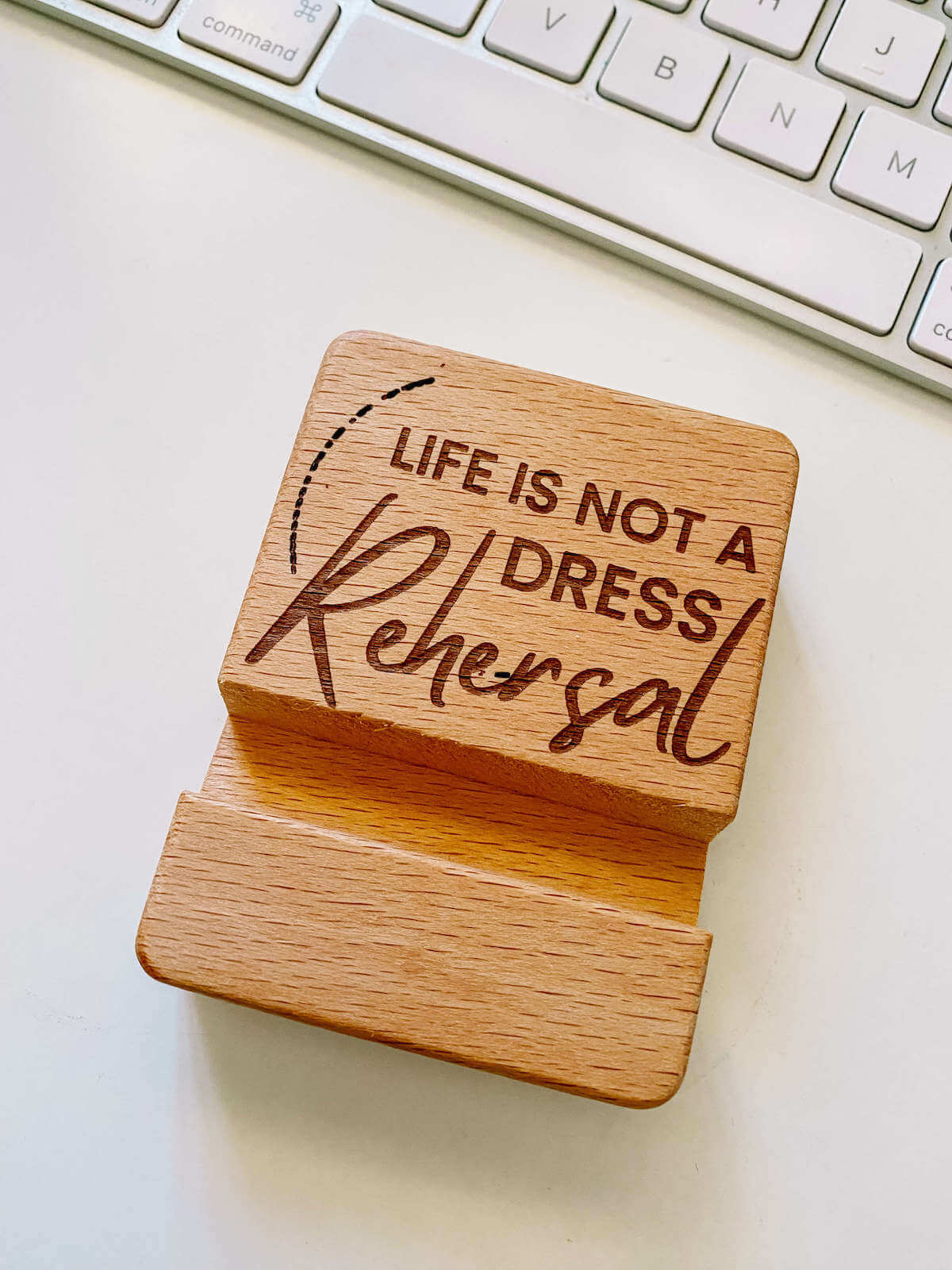 Wooden phone holder with engraved words life is not a dress rehearsal