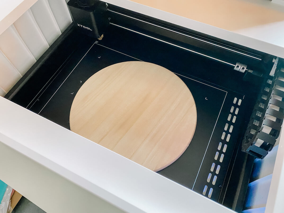 Round wooden blank inside xtool m1 laser cutting machine preparing to engrave