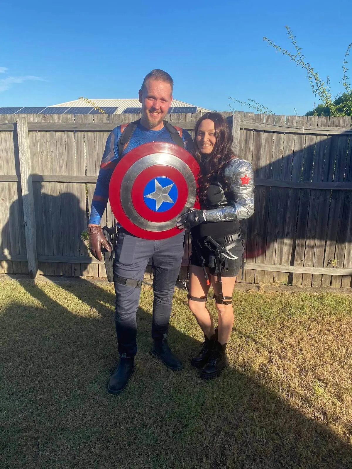 Holly and simon dressed up as captain america and the winter soldier in a backyard.
