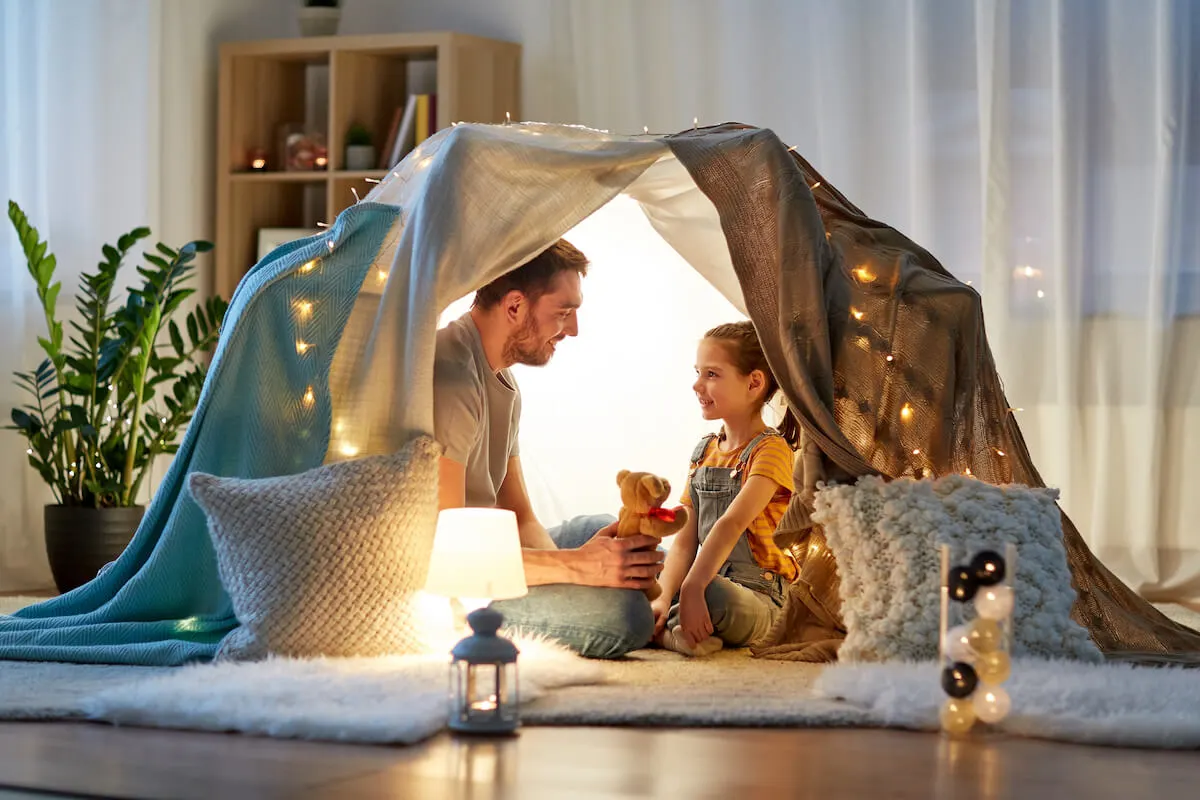 Father and daughter inside a tent in their living room