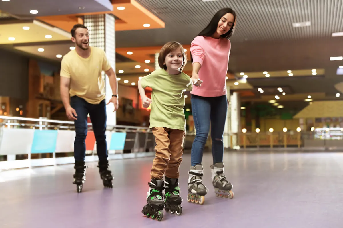 Mother father and son at rollerskating rink in rollerblades