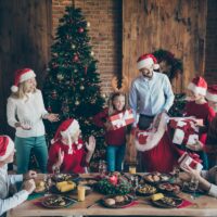 Photo of large family with small little kids senior pensioner sit table, on x-mas meal celebration in santa claus cap hat get receive wish gift boxes house having x-mas tree atmosphere spirit.